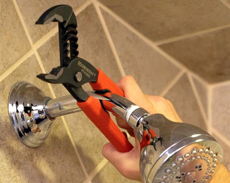 Red and black groove wrench tool fixing the shower 