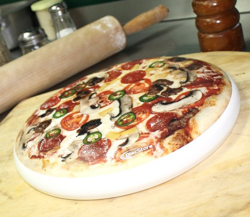 Pizza frisbee on a slab with a wooden rolling pin
