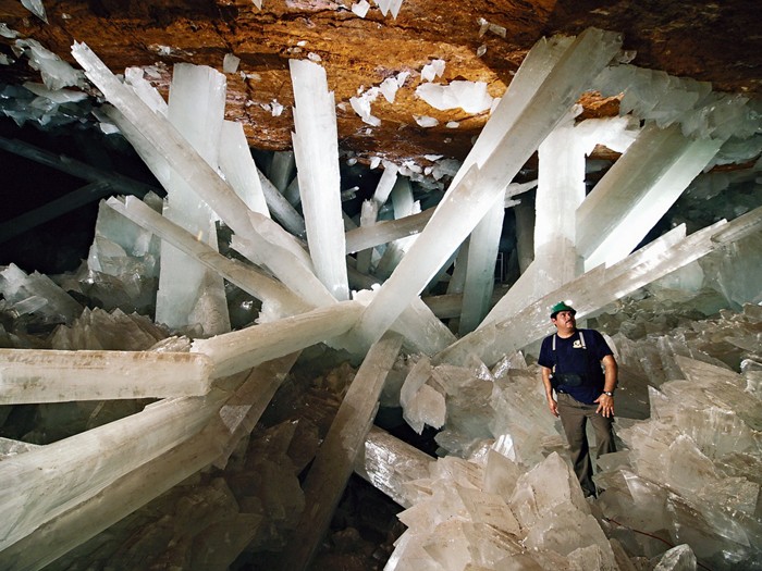 A man standing inside of a giant crystal cave