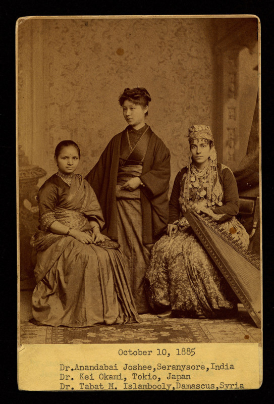 Three doctor women; one wearing saree, one wearing Japanese traditional dress, and one wearing Syrian traditional dress with jewelry with their respective names below