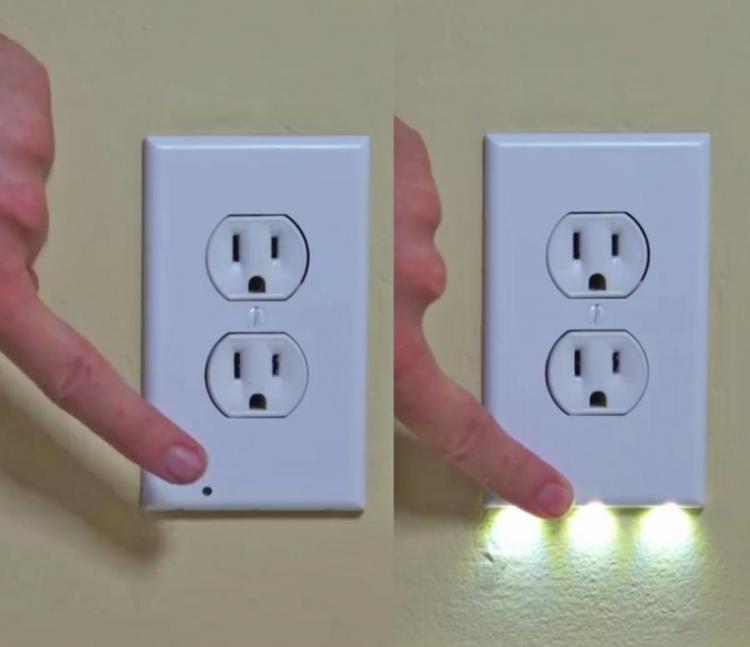 A white socket that is illuminated with mini lights on a skin wall