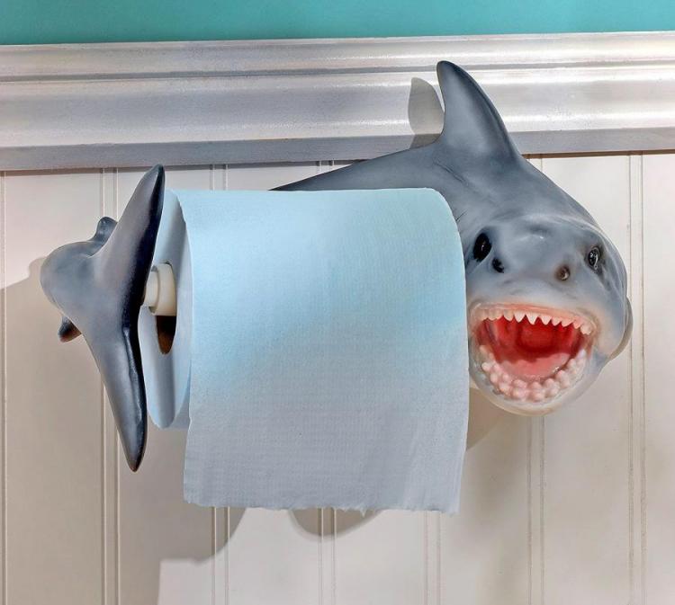 Shark-shaped toilet flush handle with a tissue roll in a bathroom
