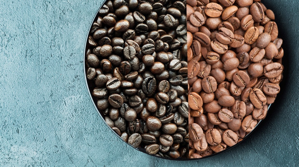 A bowl of coffee beans and on the left is a dark roast and on the right corner is the light roast coffee beans