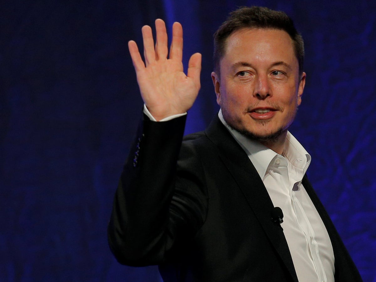 Wearing a black coat, Elon Mask is waving his hands