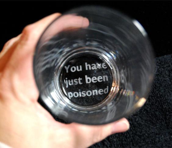 'you have been poisoned in white color printed on the bottom of a glass mug