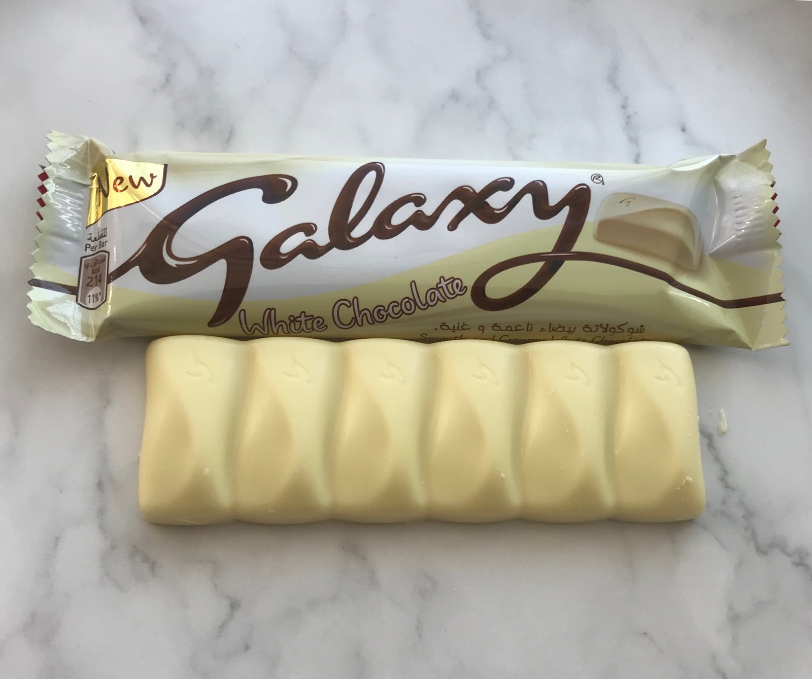 Galaxy white chocolate with wrapper pack and without a wrapper pack on a white-grey marble floor