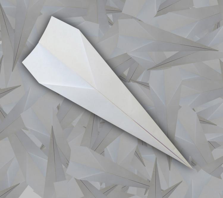 A white pre-folded airplane on a grey-dark grey bg