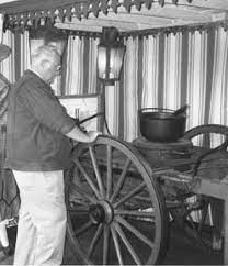 An Old Man Boiling Some Potatoes In A Black Metal Pot