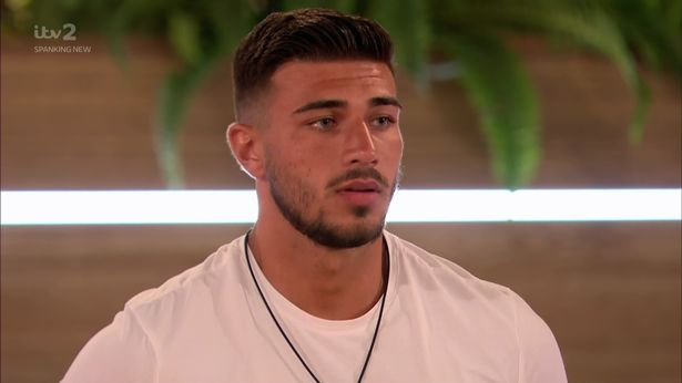 Tommy Fury wearing a white shirt and a black neckpiece