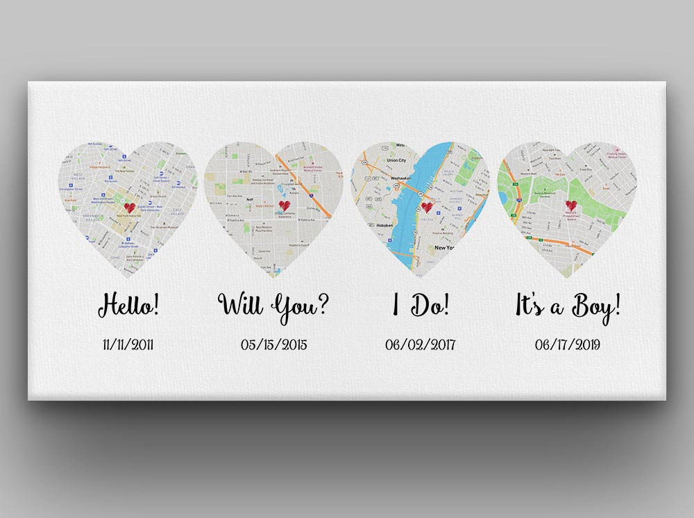 Heart-shaped maps with 'hello', 'will you,' I do'  and 'it's a boy' printed on a white background on a grey wall