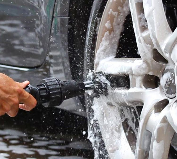 A man cleaning a car tire with black