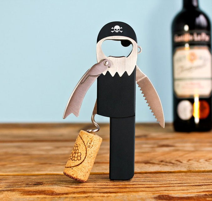 A black pirate bottle opener without one leg on a wooden surface