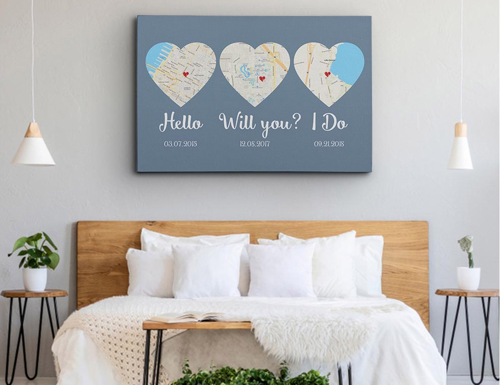 The heart-shaped map on a dark grey background on a light grey wall in a white-grey bedroom with some plants