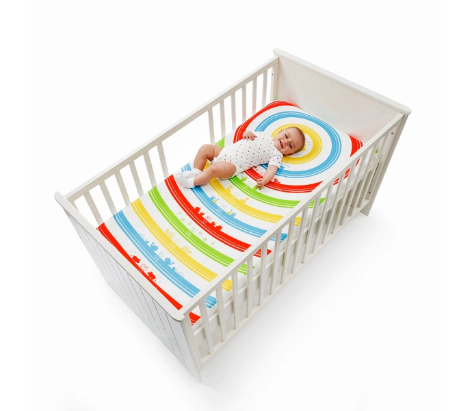 A white-colored baby bedsheet with multi-colored lines in a white baby cart