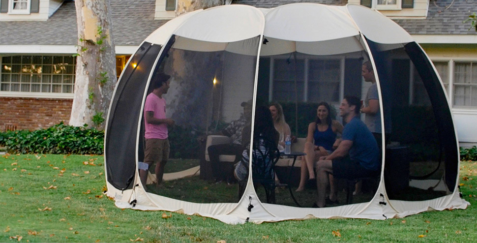 7 people in the screened tent in front of a house