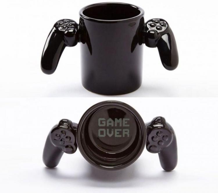 Black colored coffee mug with black controllers with 'game over' imprinted inside the bottom of the mug