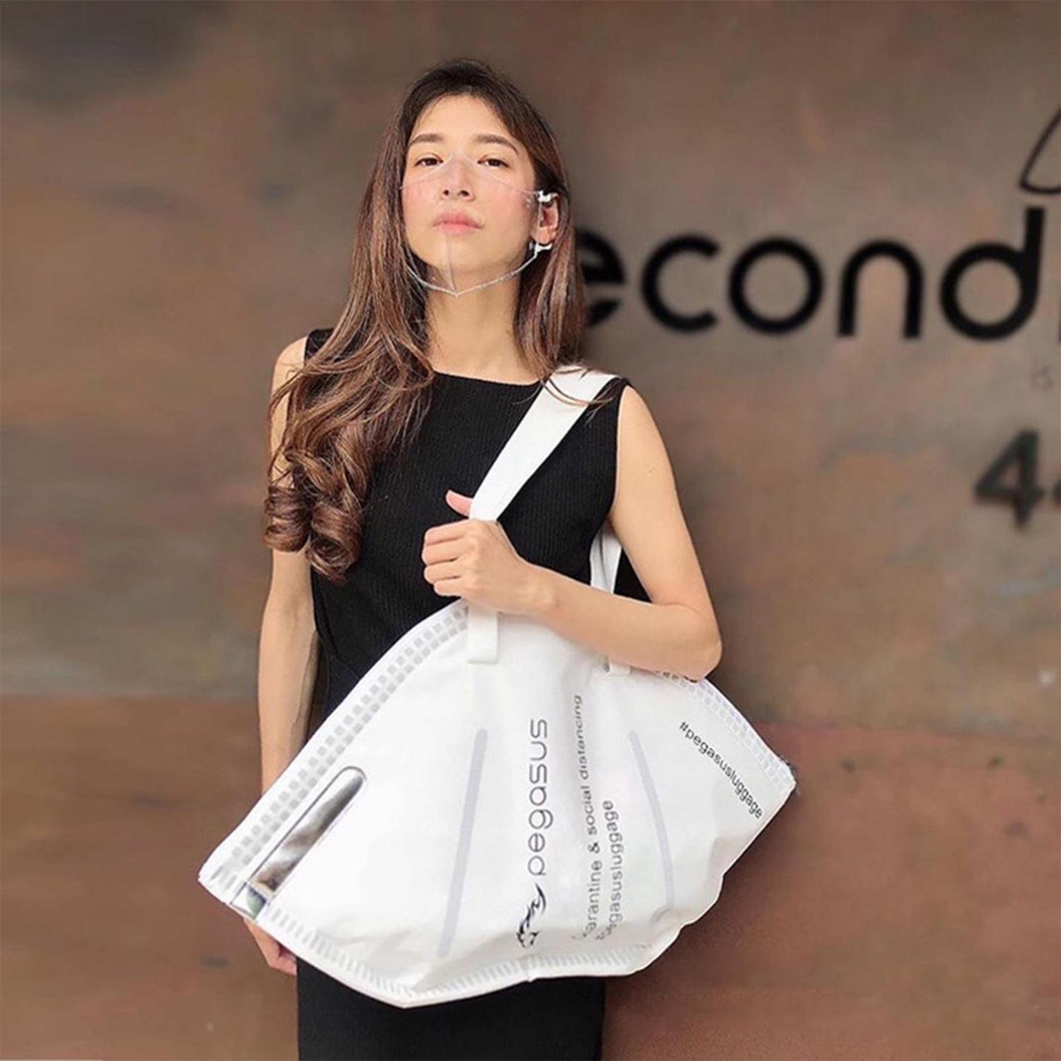 A girl wearing black dress holding a white Giant Face Mask Tote Bag