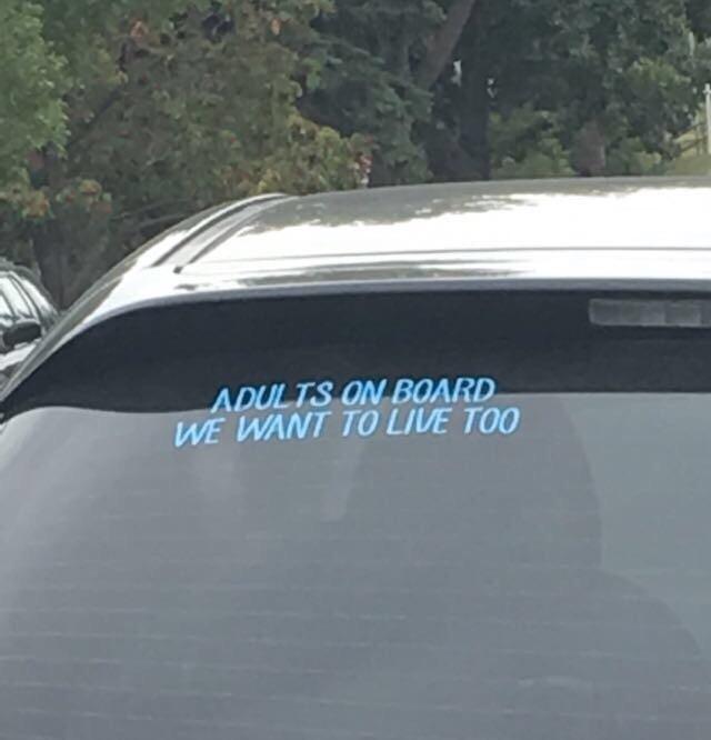 Adults on board sign in the back of a car