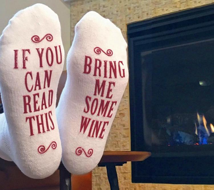 White-colored socks with red-colored 'bring me some wine' printed on it