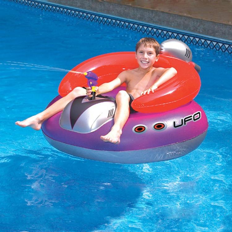 A boy sitting on a red, purple, and grey UFO-themed float in a swimming pool