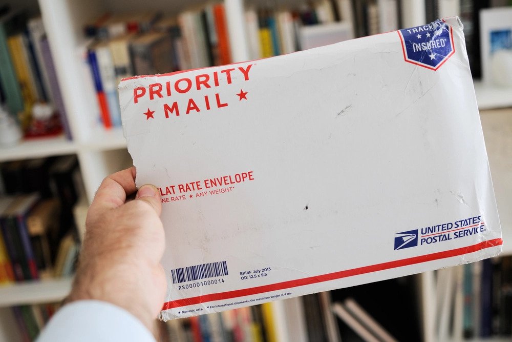 A man holding a priority mail envelope