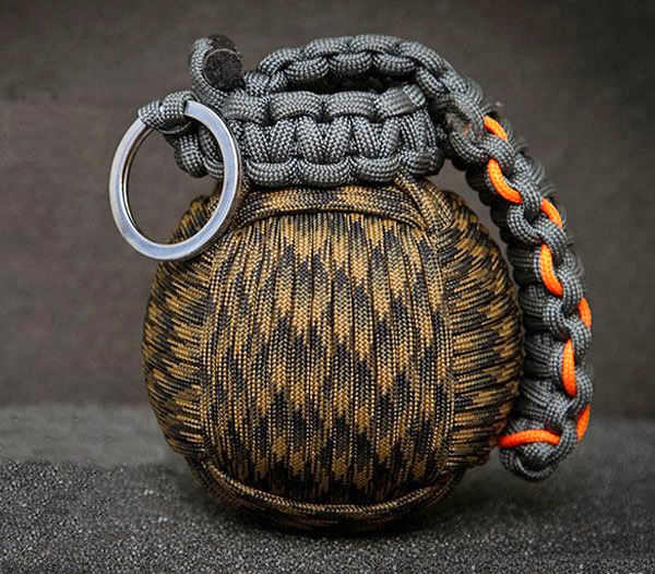 A brown and black-colored Paracord Survival Grenade on a grey surface