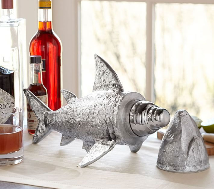 Silver-colored, shark-shaped cocktail shaker with a vine bottle and a glass