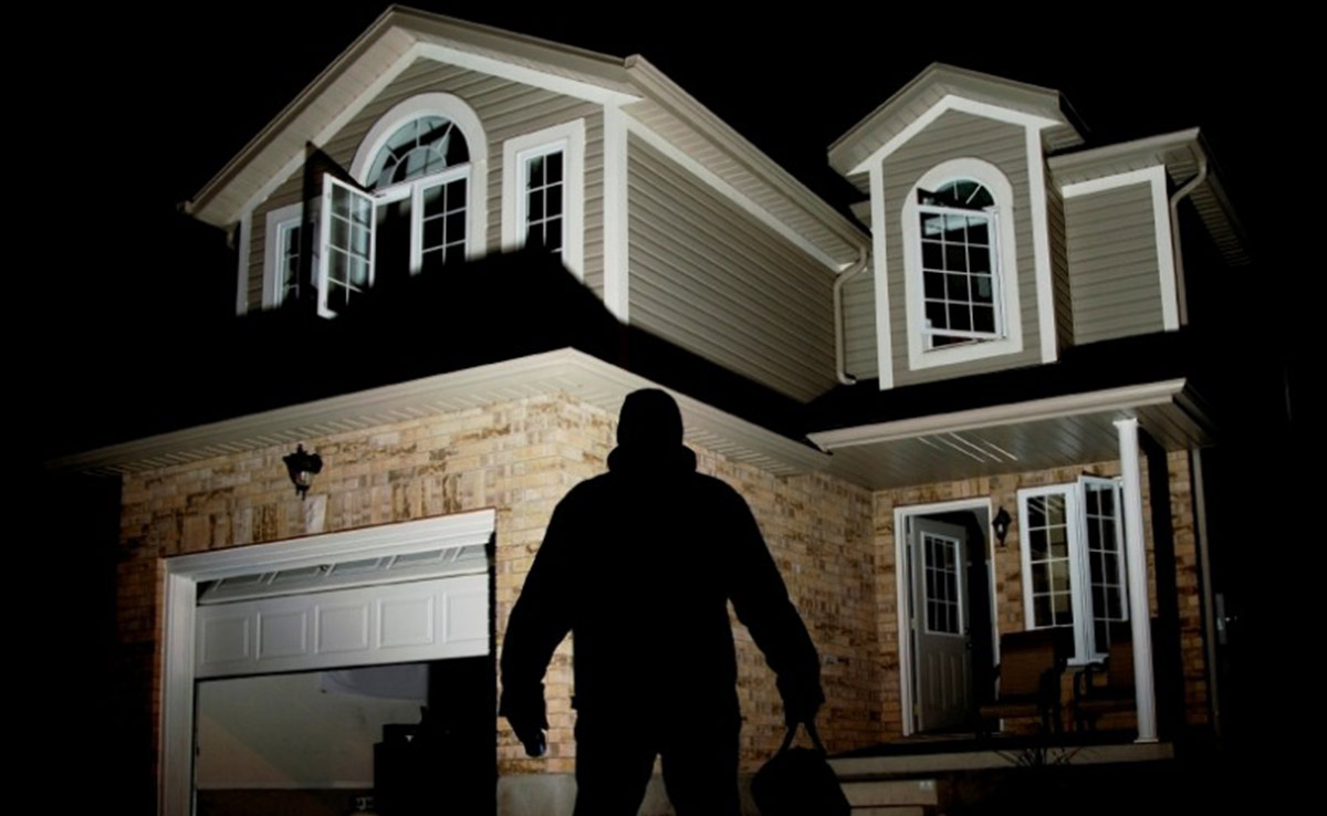 A suspicious silhouette of a man looking at a two storey house