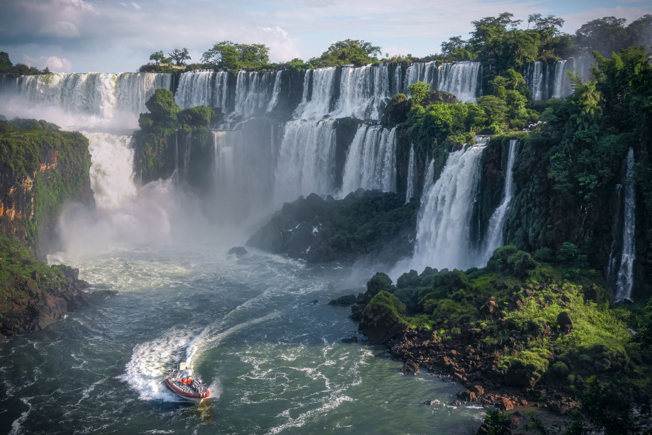 A beautiful shot of iguaza falls with a small boat