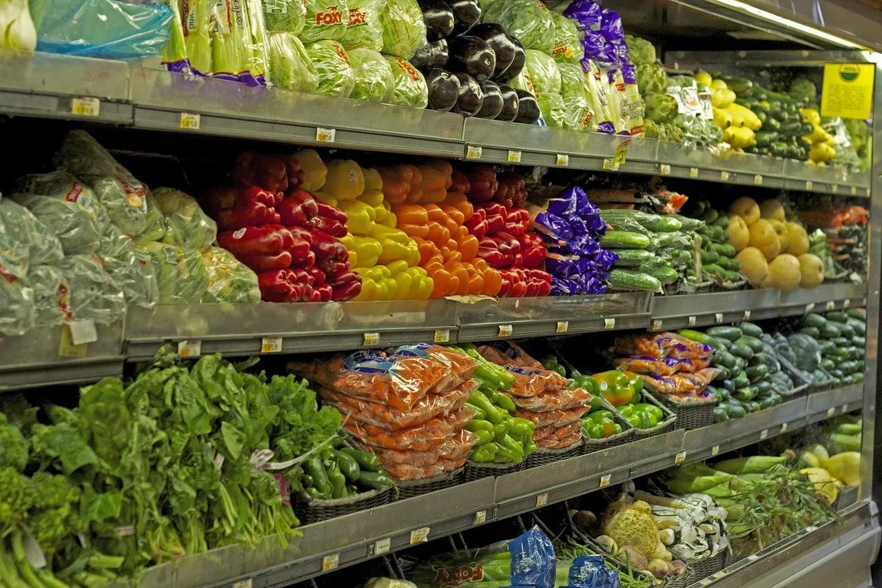 Different vegetables stacked on shelves in a supermarket