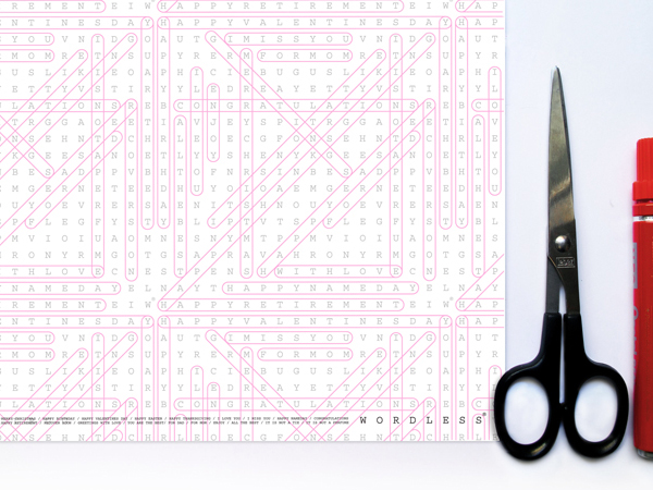 White word search wrapping paper with black scissors and re marker on white surface