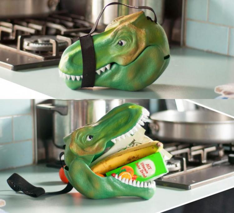 Green colored dinosaur lunchbox on kitchen top near black stove