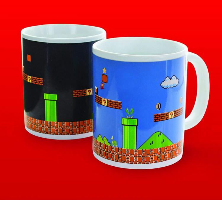 Two heat sensor Mario themed mugs on a red background; one with blue color background and one with black colored background with Mario game graphics imprinted on them