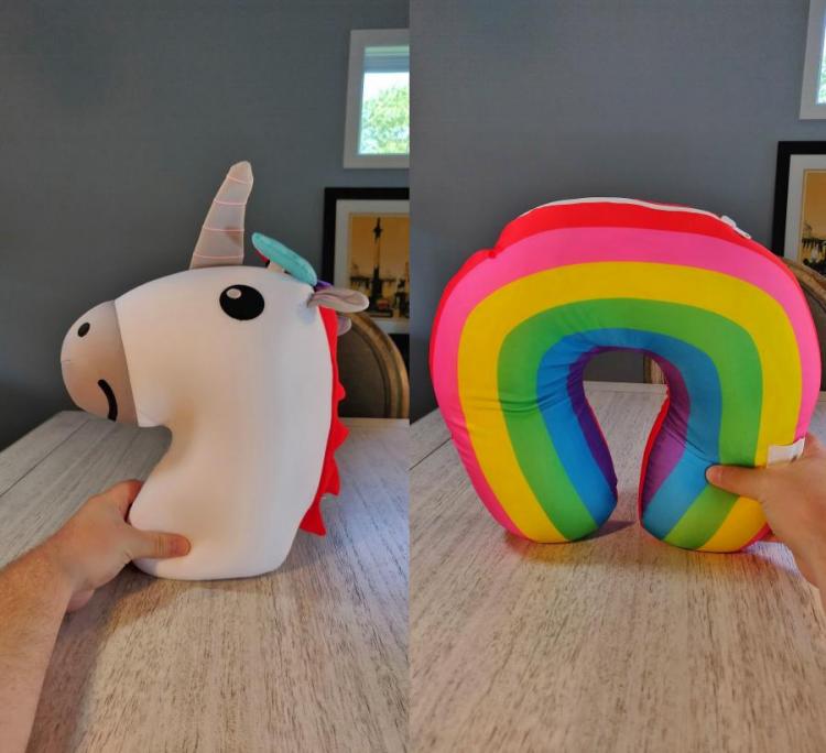 A white unicorn with a multi-colored hair pillow, which converts into a rainbow pillow, placed on a wooden table