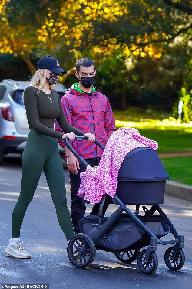 Sophie and Joe enjoying a walk in the park with their baby Willa
