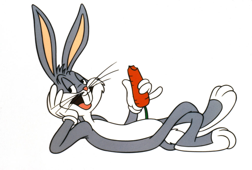 Bugs Bunny lays on his back with carrot in hand