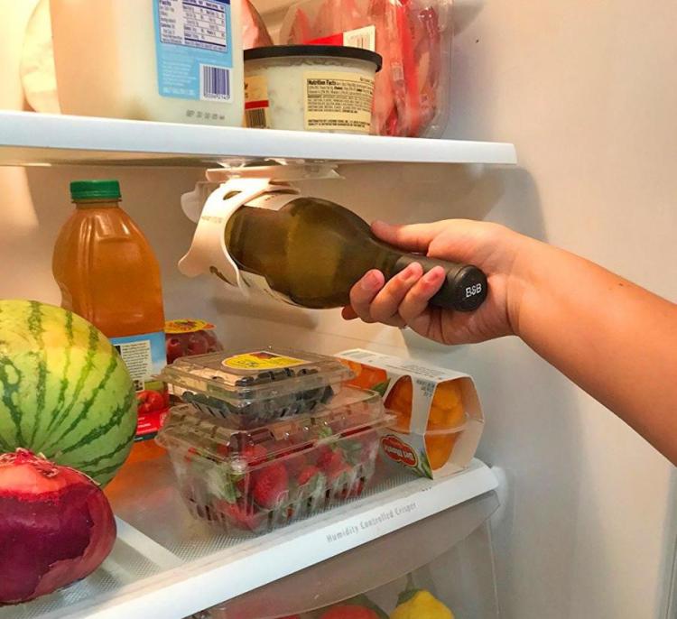 A white wine bottle holder holding a dark green bottle inside a fridge