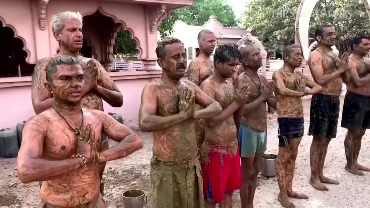 People performing religious ritual after bathing in cow poop