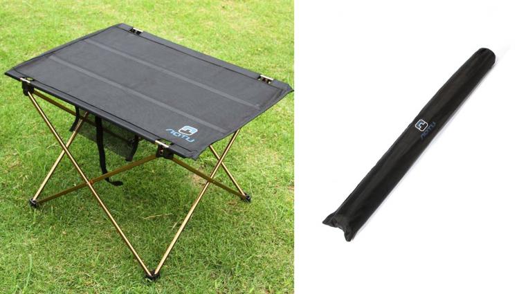 The black colored folded table on the grass