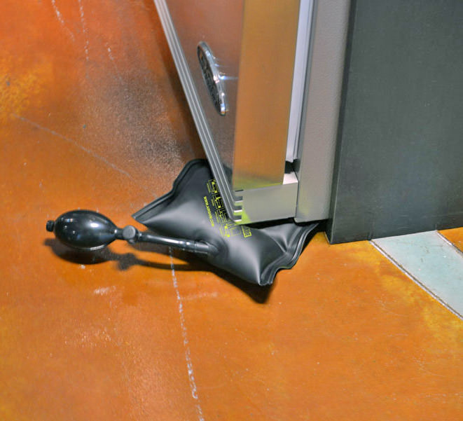 Black colored levelling tool levelling fridge on a brown marble floor