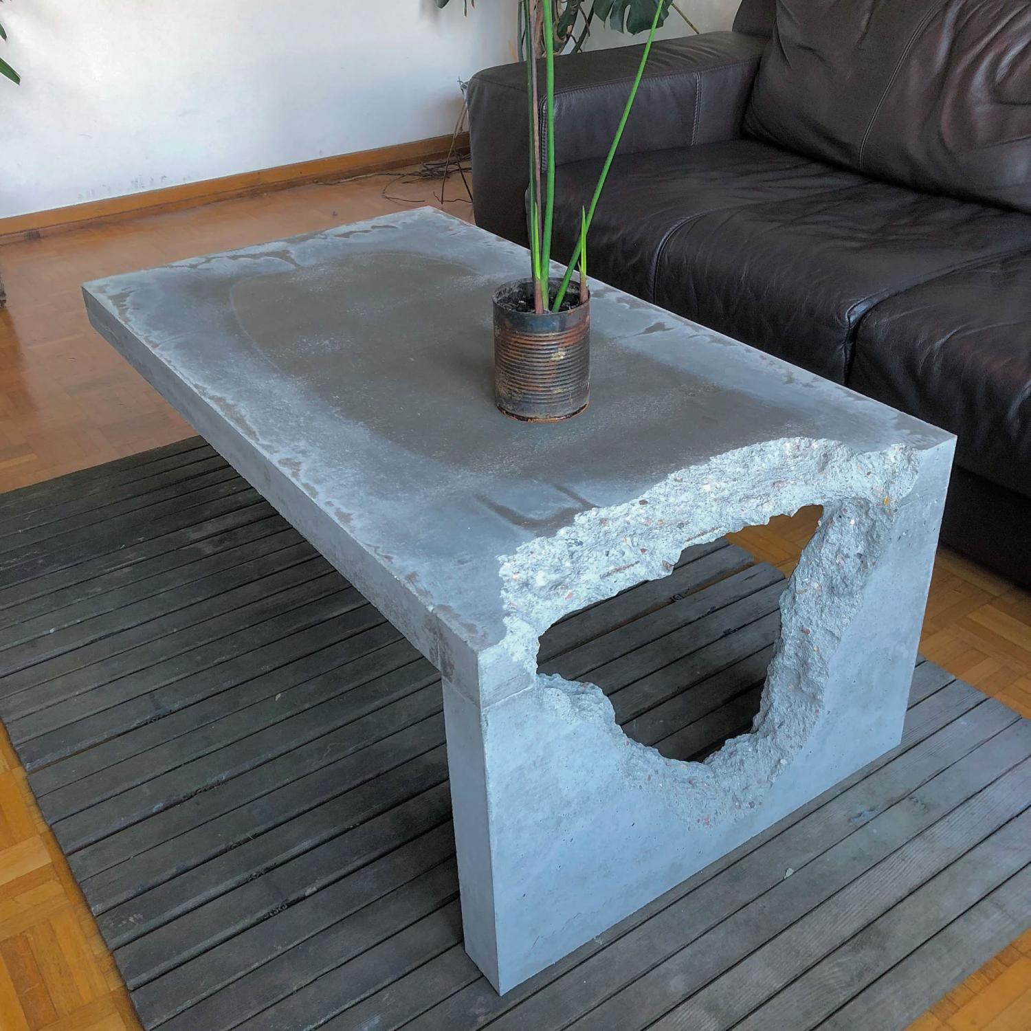 White-grey concrete coffee table on a grey striped rug