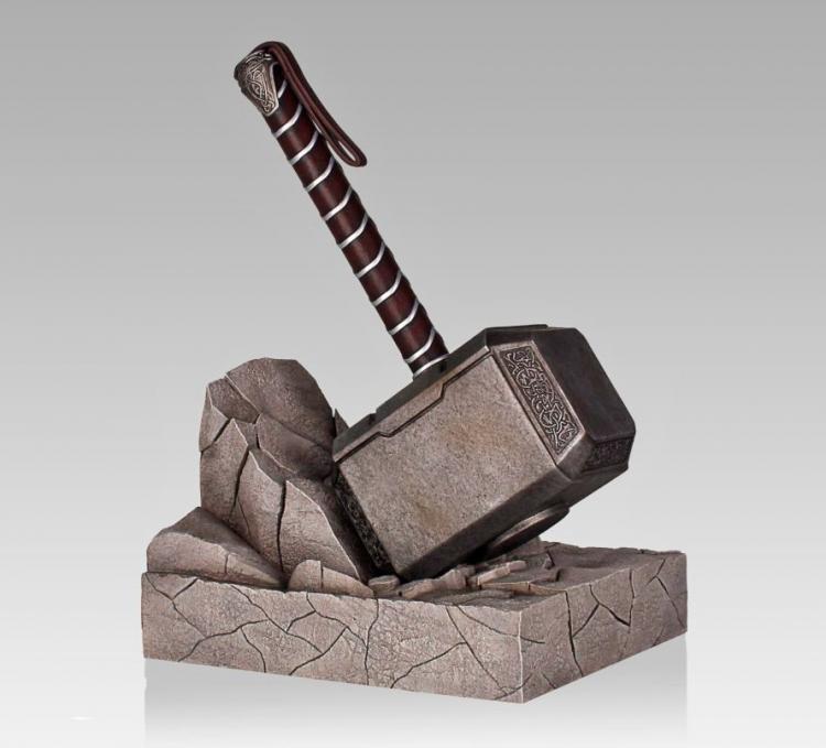 A grey colored thor hammer on a grey colored block of a rock