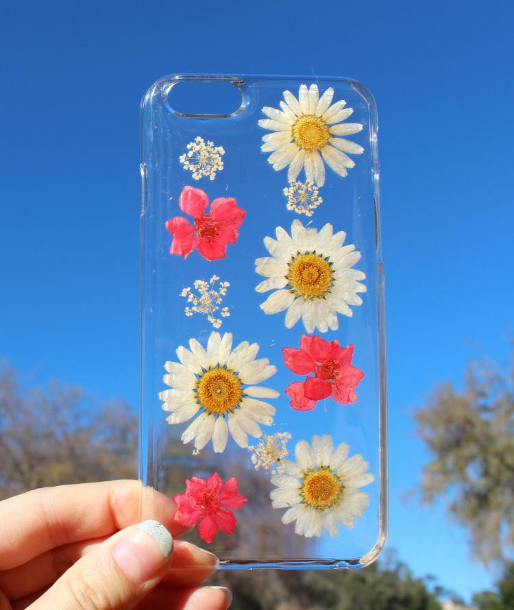 White daisy and pink flower pressed into a transparent phone case 