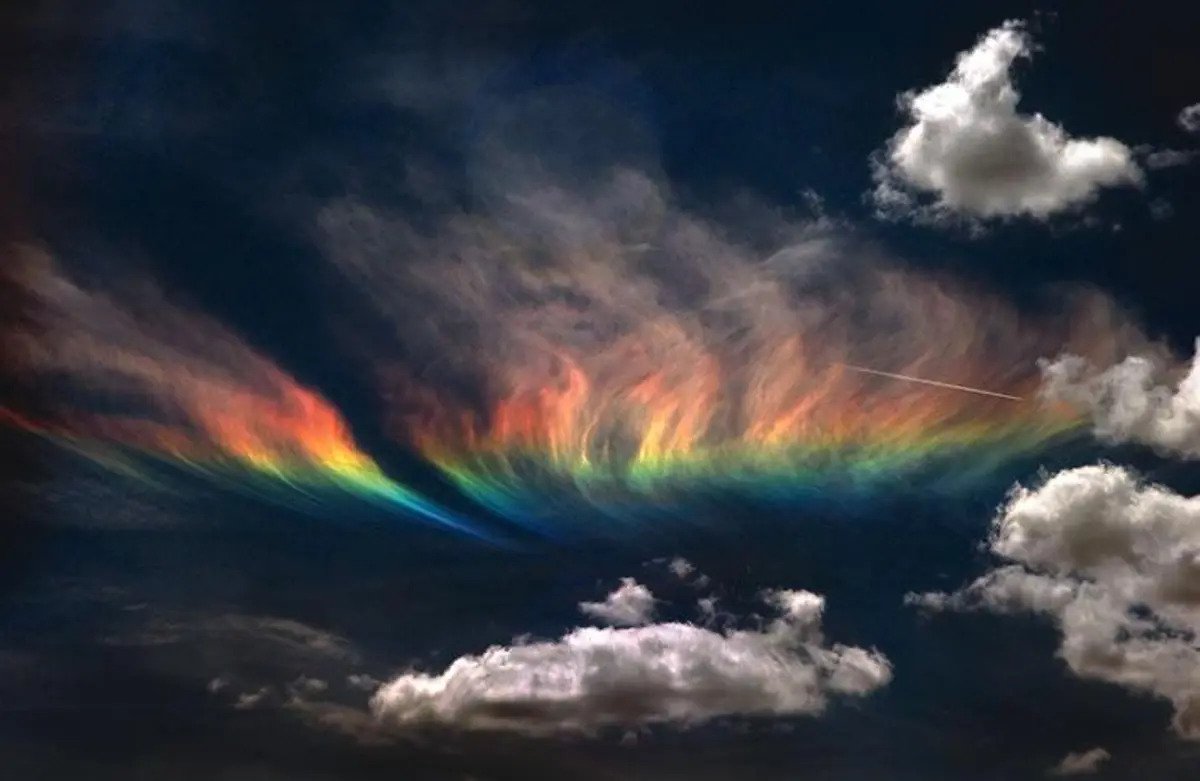 Fire rainbow with clouds on a dark grey sky background