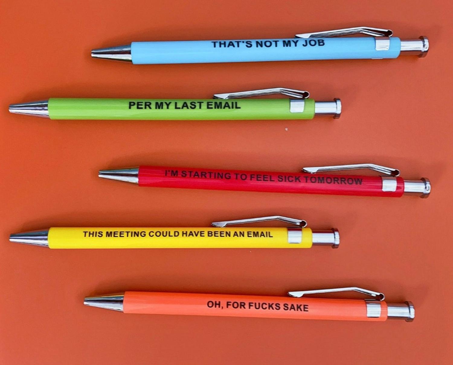 Red, yellow, green, blue, and orange colored Offensive Office Pens on a red-orange surface
