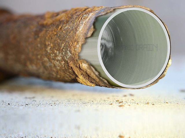 A grey colored pipe in the old rusty pipe