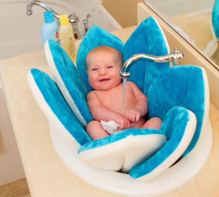 A kid enjoying a bath in a blue and white water-safe padded blossom in a skin bath tub