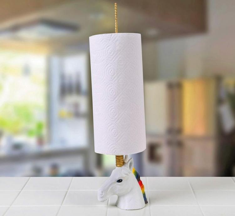 A golden horned unicorn holding a paper cloth roll placed on a kitchen top