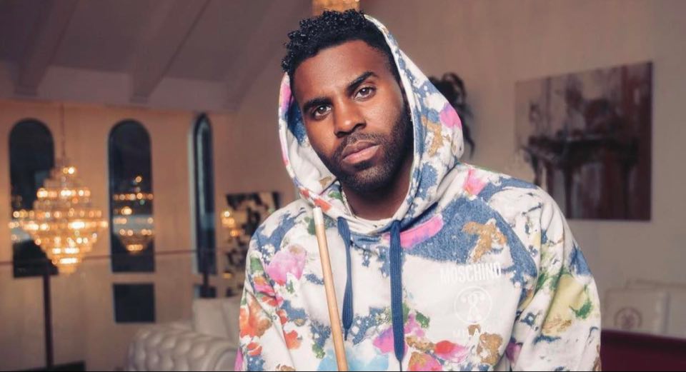 In his room, Jason Derulo in a hoddie outfit and fiercely look at the camera 