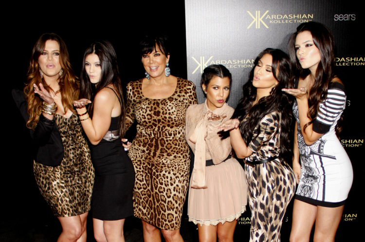 The Kardashians smiling and posing blowing kisses